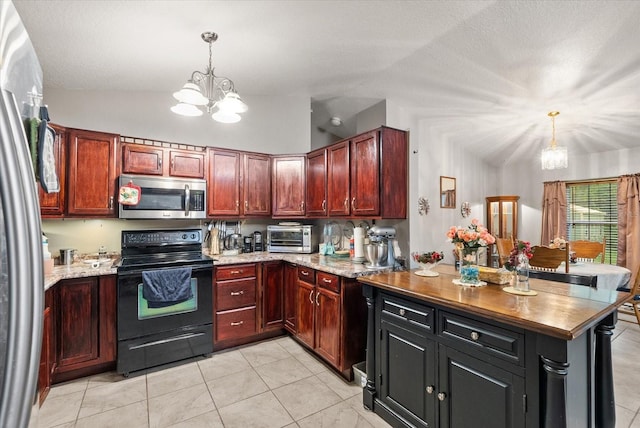 kitchen featuring stainless steel appliances, lofted ceiling, light tile patterned floors, a chandelier, and pendant lighting