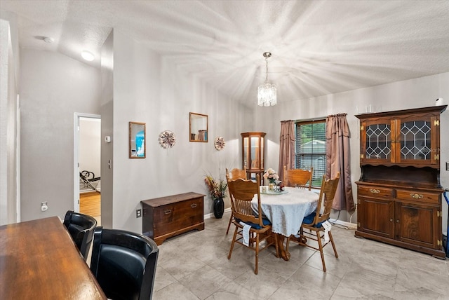 dining area featuring a notable chandelier and a textured ceiling