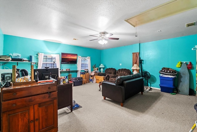 carpeted living room featuring ceiling fan and a textured ceiling