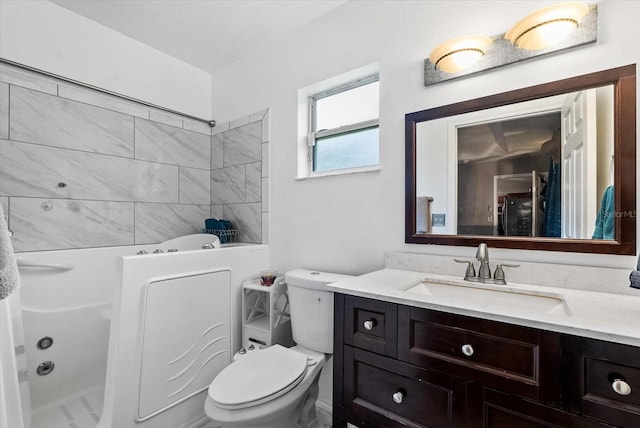 bathroom with a bathtub, vanity, and toilet