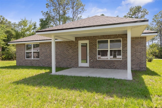 17 Service Berry Pl, Palm Coast, FL 32164 - back of house featuring brick siding, a lawn, and a patio
