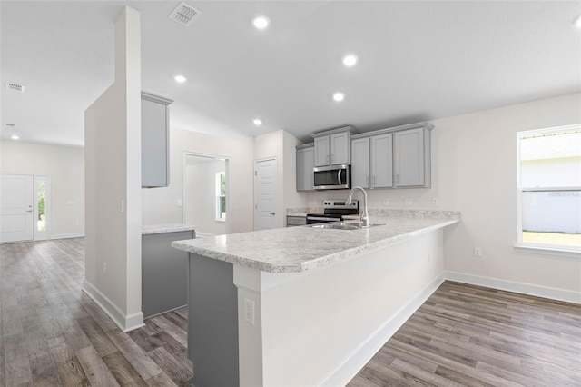 17 Service Berry Pl, Palm Coast, FL 32164 - kitchen featuring appliances with stainless steel finishes, gray cabinets, light countertops, wood finished floors, and recessed lighting