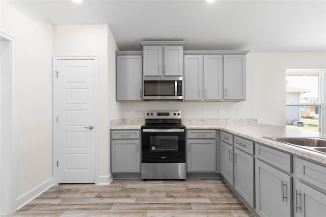 17 Service Berry Pl, Palm Coast, FL 32164 - kitchen with stainless steel appliances, gray cabinets, and light wood-type flooring