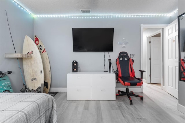 bedroom featuring a textured ceiling and light hardwood / wood-style floors