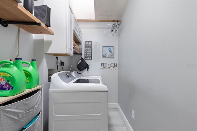 laundry room featuring washing machine and clothes dryer and light hardwood / wood-style floors