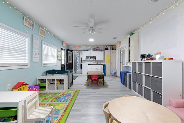 playroom with light hardwood / wood-style floors, ceiling fan, and sink