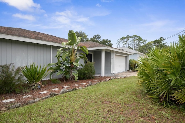 exterior space featuring a garage and a front lawn