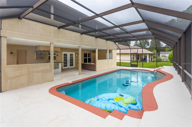 view of pool with glass enclosure, french doors, and a patio