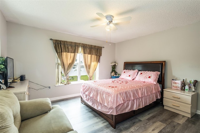 bedroom with a textured ceiling, ceiling fan, and dark wood-type flooring