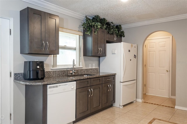 kitchen featuring a textured ceiling, white appliances, dark brown cabinets, and sink