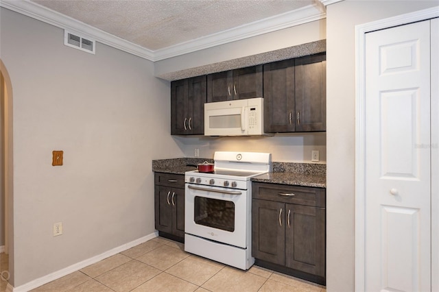 kitchen with dark brown cabinetry, light tile patterned flooring, white appliances, and ornamental molding