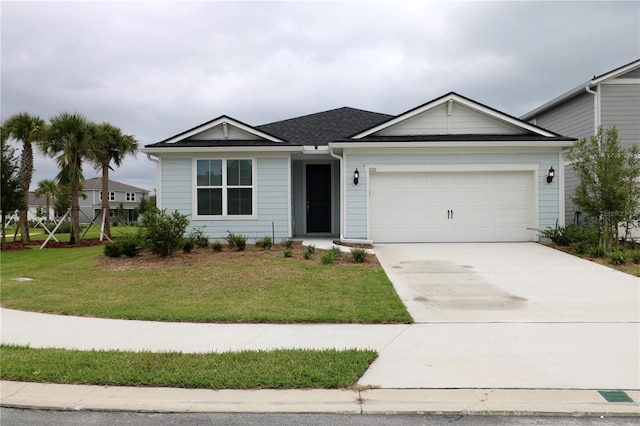 view of front of house with a front yard and a garage