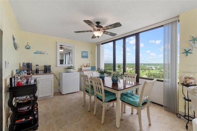 tiled dining space with ceiling fan