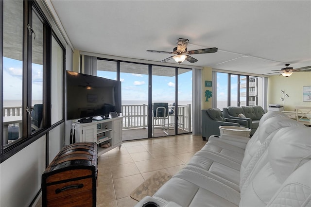 living room with floor to ceiling windows, light tile patterned floors, and ceiling fan