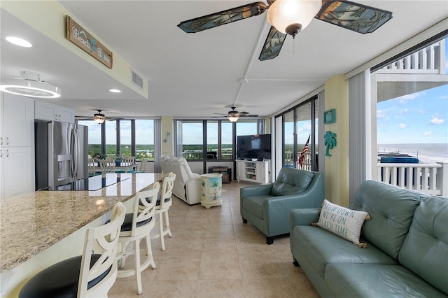 living room featuring light tile patterned floors and ceiling fan