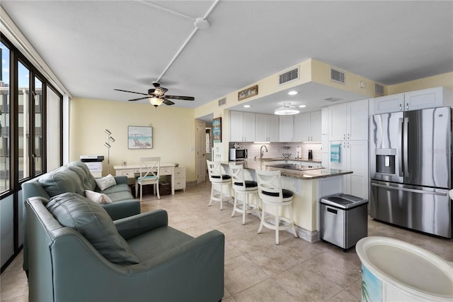 tiled living room featuring ceiling fan and sink