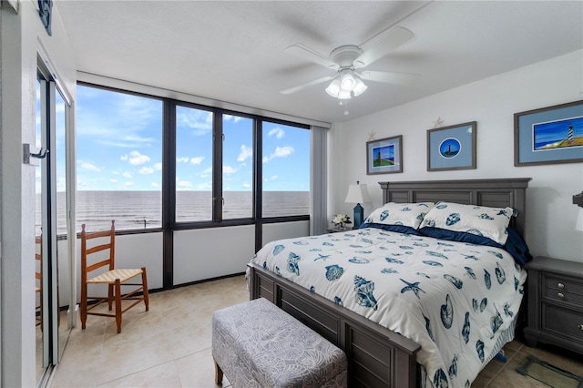 tiled bedroom featuring a water view, multiple windows, and ceiling fan