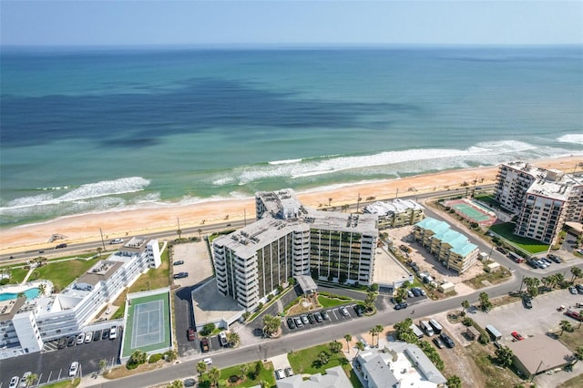 drone / aerial view featuring a water view and a beach view