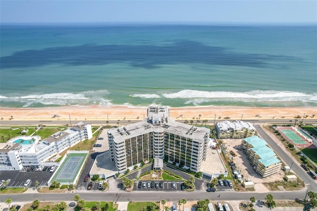 birds eye view of property featuring a water view and a beach view