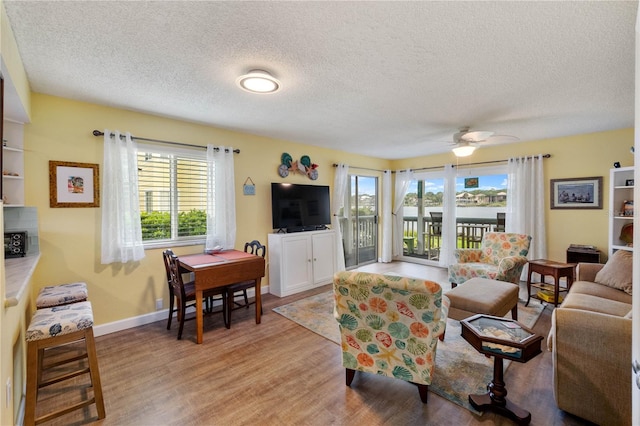 living room featuring a textured ceiling, plenty of natural light, ceiling fan, and light hardwood / wood-style floors