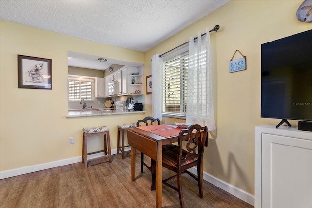 dining room with a textured ceiling and wood-type flooring