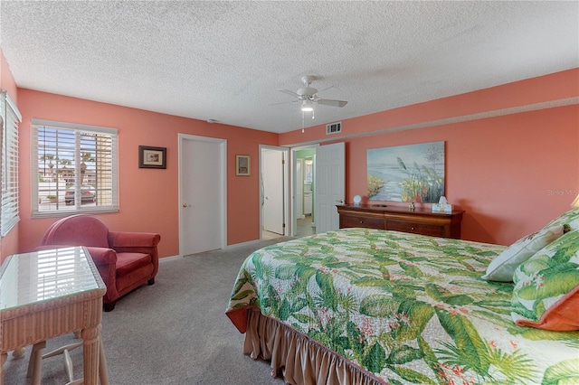 bedroom featuring ceiling fan, light colored carpet, and a textured ceiling