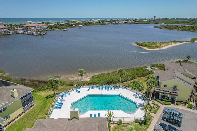 view of swimming pool with a water view and a patio