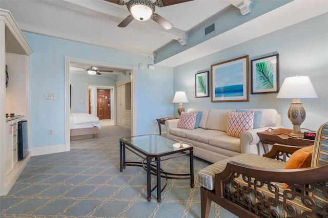 living room with ceiling fan, dark colored carpet, and ornamental molding