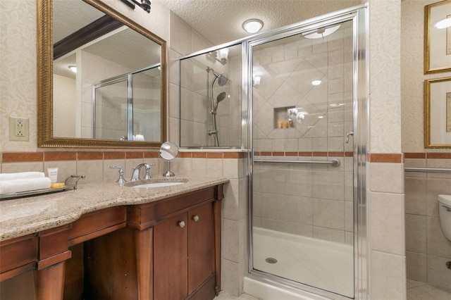 bathroom featuring walk in shower, vanity, and a textured ceiling