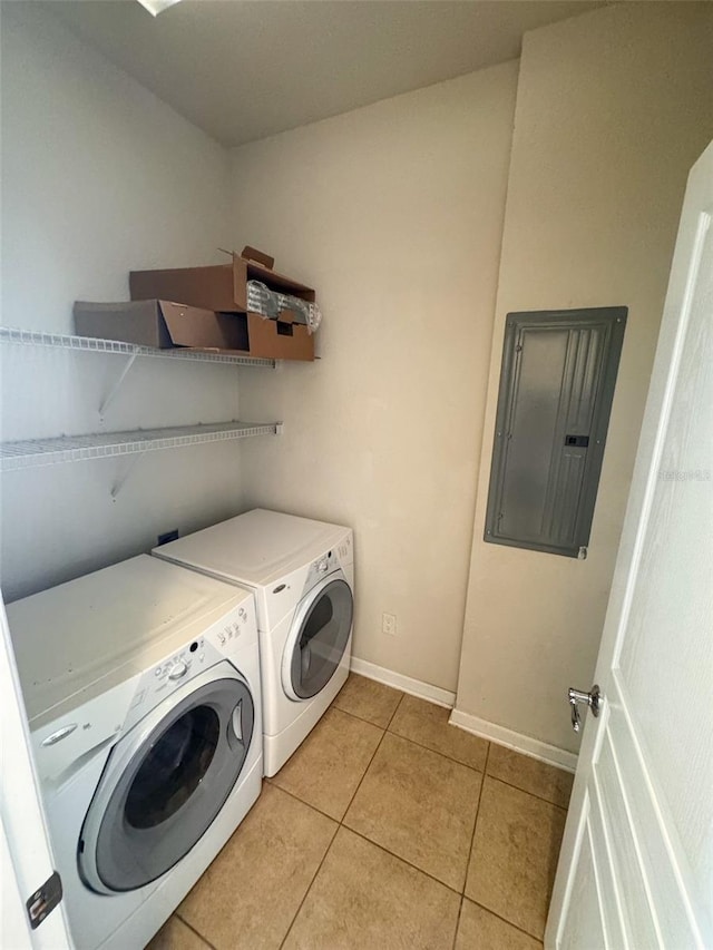 clothes washing area featuring light tile patterned flooring, electric panel, and separate washer and dryer