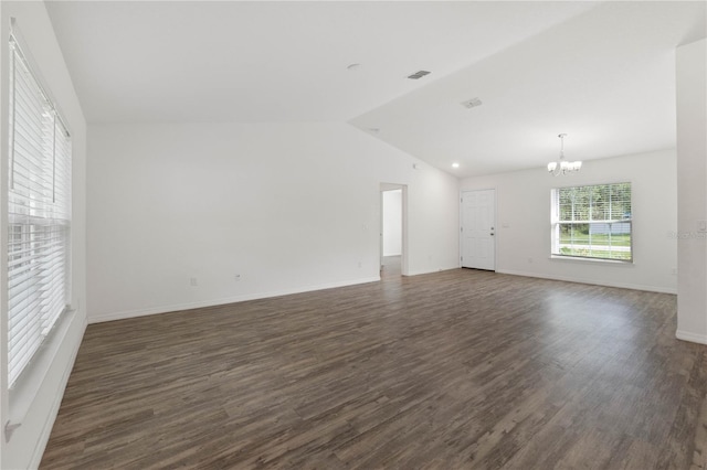 unfurnished living room with dark hardwood / wood-style floors, vaulted ceiling, and a chandelier