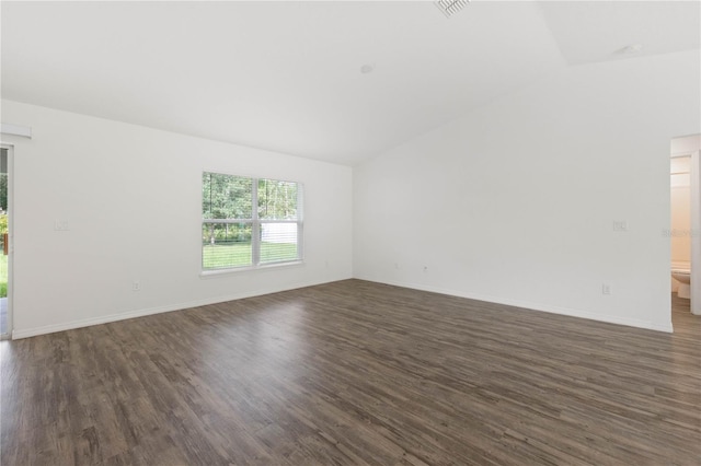 spare room with lofted ceiling and dark wood-type flooring