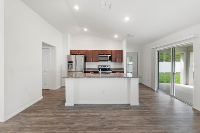 kitchen with an island with sink, vaulted ceiling, appliances with stainless steel finishes, and dark hardwood / wood-style floors