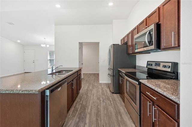 kitchen featuring sink, stone counters, a chandelier, stainless steel appliances, and light hardwood / wood-style floors