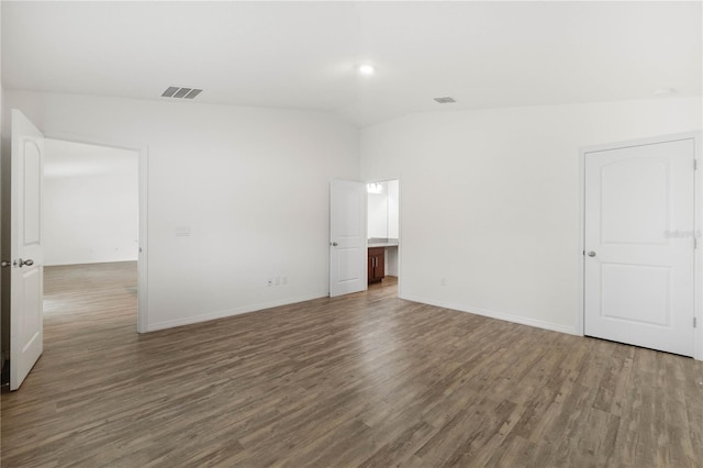 spare room with lofted ceiling and dark hardwood / wood-style flooring