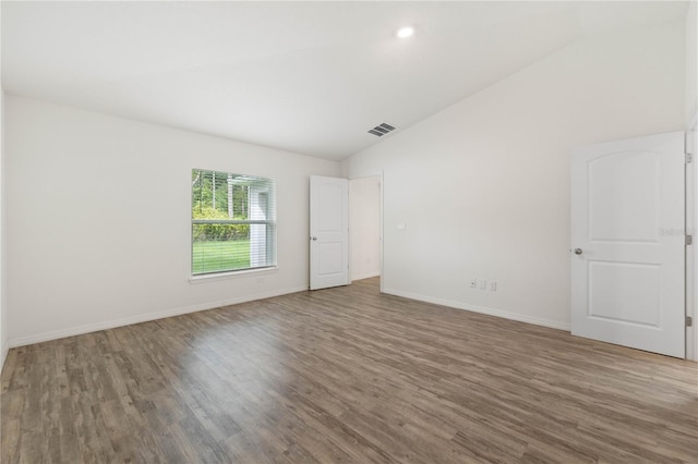 empty room featuring wood-type flooring and lofted ceiling