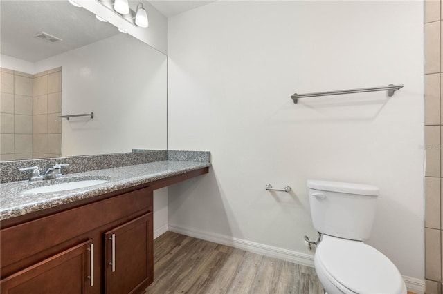 bathroom with wood-type flooring, vanity, and toilet