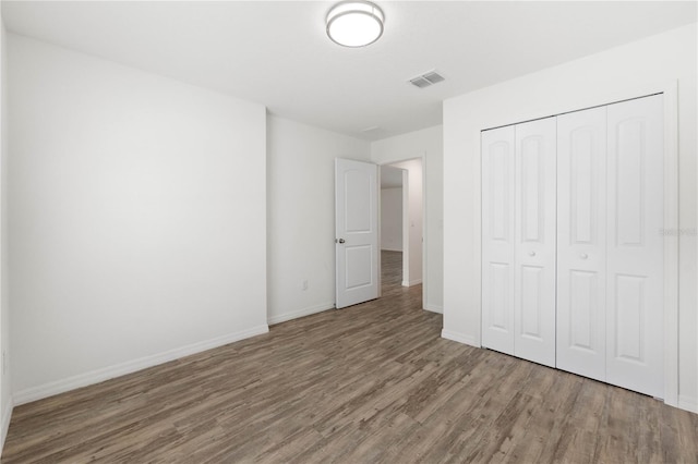 unfurnished bedroom with hardwood / wood-style floors and a closet