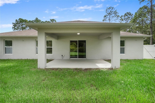 rear view of house with a lawn and a patio