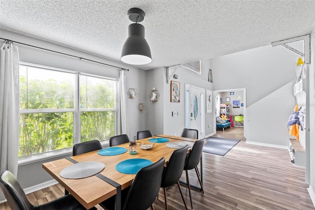 dining room featuring hardwood / wood-style flooring and a textured ceiling