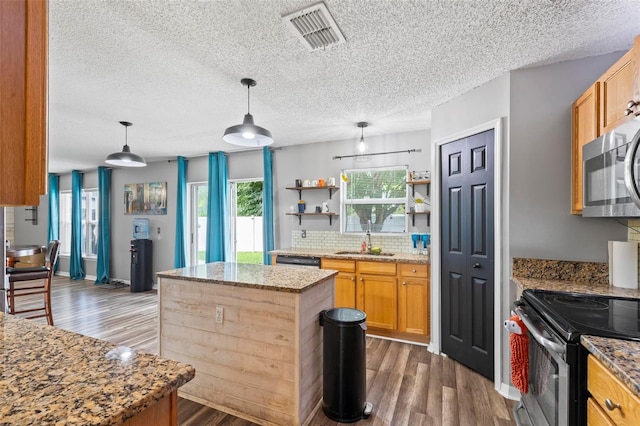 kitchen with dark hardwood / wood-style flooring, stainless steel appliances, a textured ceiling, a center island, and sink