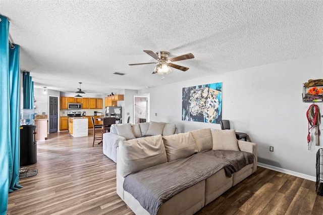 living room featuring a textured ceiling, hardwood / wood-style floors, and ceiling fan