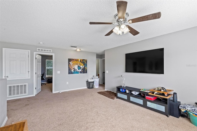 carpeted living room featuring a textured ceiling and ceiling fan