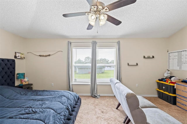 bedroom with ceiling fan, a textured ceiling, and light carpet