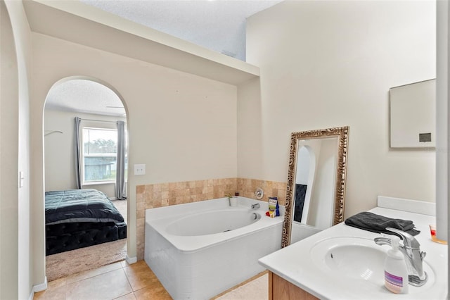 bathroom featuring vanity, tile patterned flooring, a textured ceiling, and a bathtub