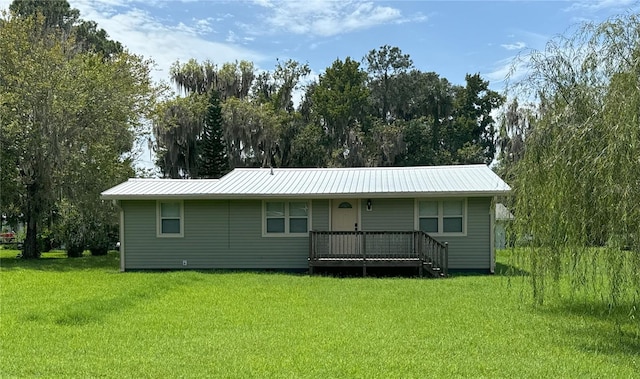 rear view of property featuring metal roof and a yard