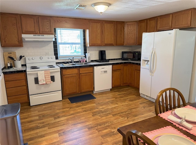 kitchen with tile counters, white appliances, a sink, and under cabinet range hood