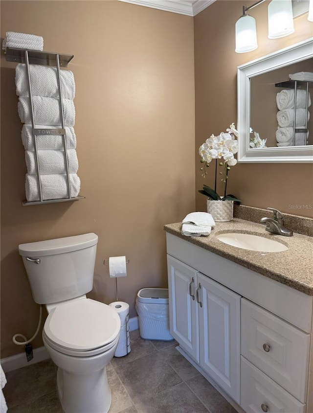 bathroom with toilet, baseboards, and vanity