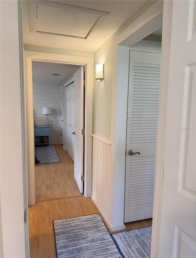 hallway featuring light wood-type flooring and attic access