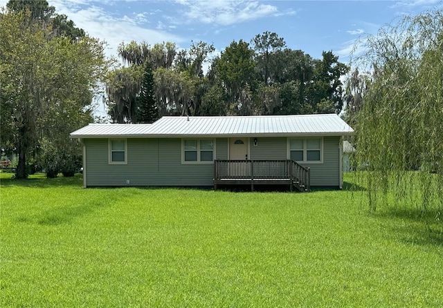 back of property with metal roof and a lawn